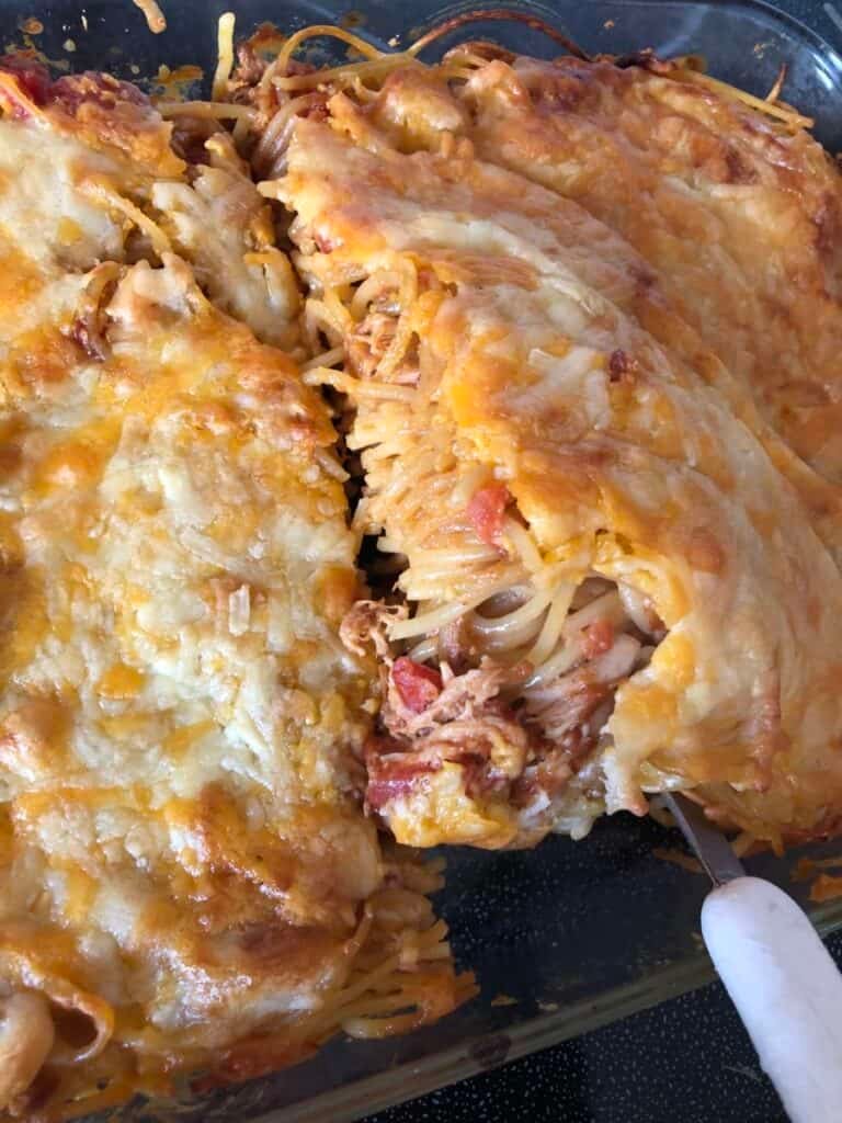 cooked chicken spaghetti bbq casserole being removed from the pan